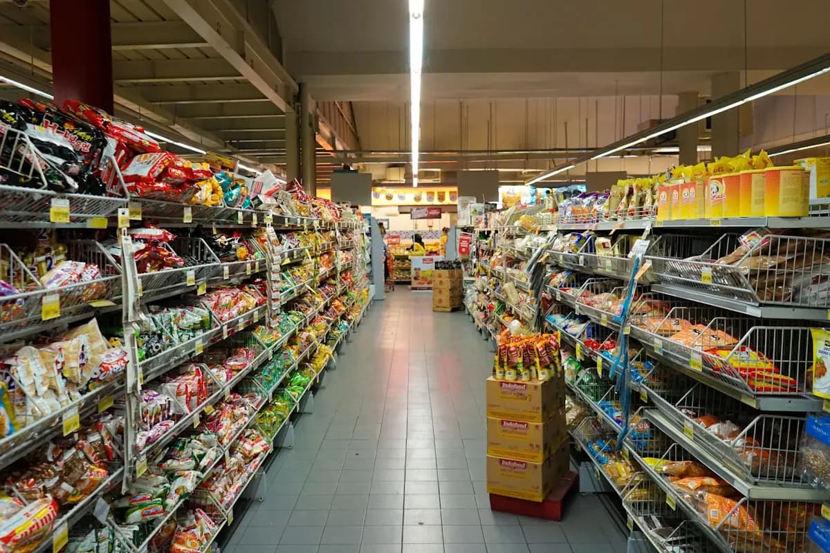 Stocked grocery aisle inside a military commissary showing rows of packaged food on shelves